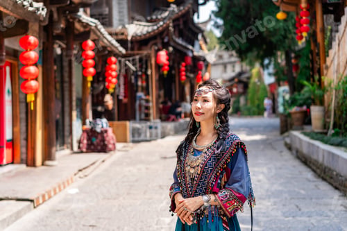 Preview: Young female tourist in traditional dress walking at Furong old Town