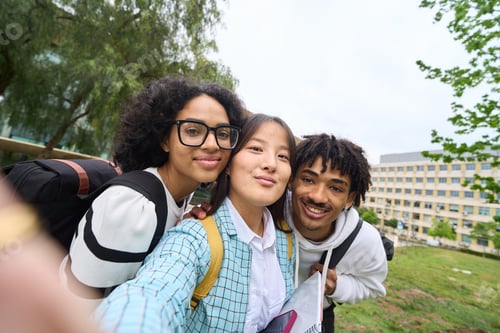 Preview: Three young students are posing for a picture in front of a building - selfie concept