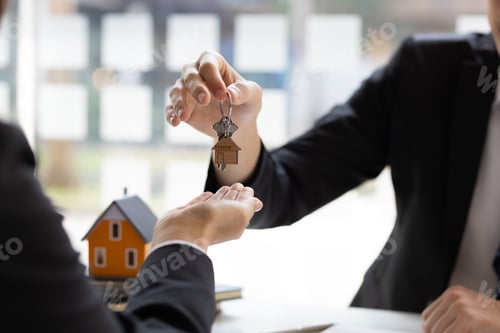 Preview: Real estate agent hand over the house key to homebuyer after the purchase agreement has been signed.