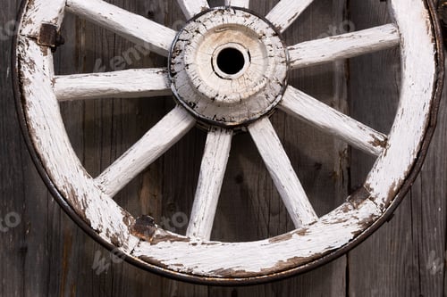 Preview: An old wooden carriage wheel hanging on the barn wall