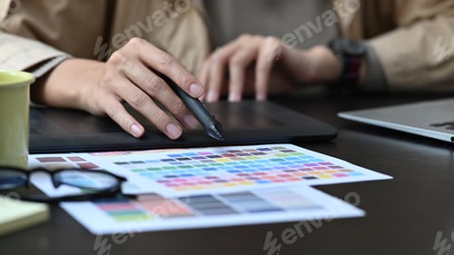 Preview: Cropped shot creative designer working with color swatches on office desk.