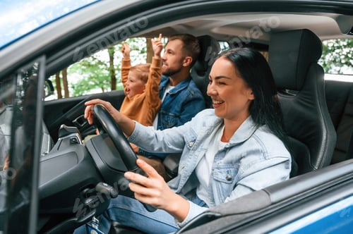 Preview: On a trip. Family of father, mother and little son are sitting in the modern car