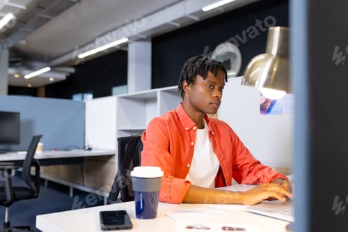 Preview: In modern office, African American male managing tasks at computer
