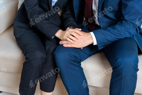 Preview: cropped shot of young business couple holding hands