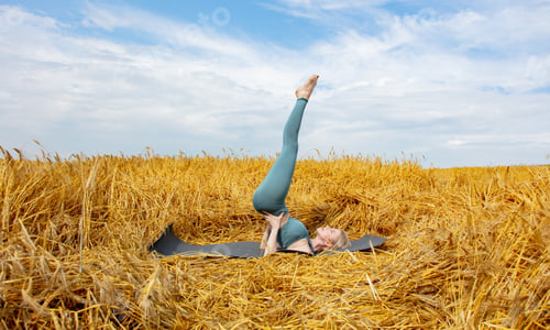 Preview: girl practices yoga in a wheat field