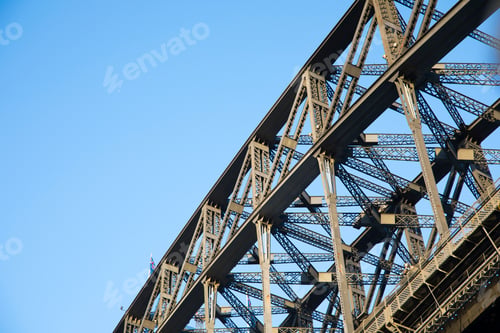Preview: Isolated close up view of the Sydney Harbour Bridge from beneath against a blank blue sky