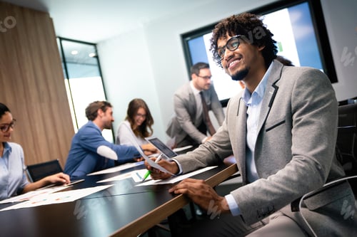 Preview: Group of young business people working and communicating at the office