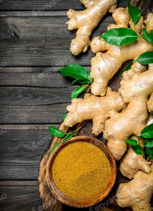 Preview: Fresh and ground ginger with leaves on the cutting Board.