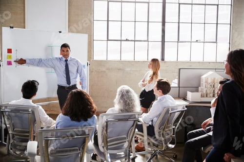 Preview: Businessmastands using whiteboard during a presentation
