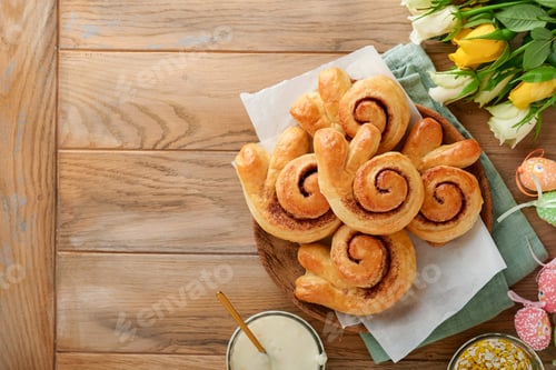 Vista previa: Concepto navideño de desayuno de Pascua. Rollos de bollos de conejo de Pascua con canela hechos de masa de levadura
con