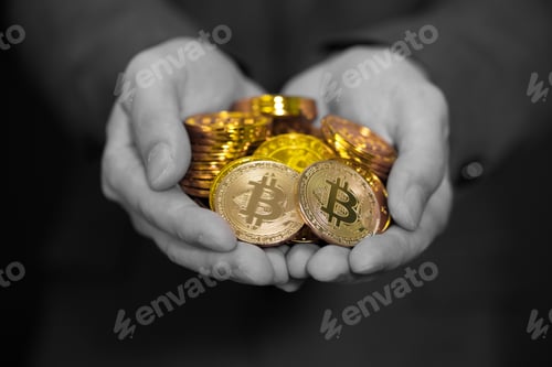 Preview: Close-up of businessman's hands full of bitcoin sign of coins in black and white