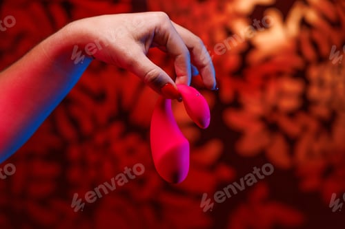 Preview: A small pink vibrator for intimate play is elegantly displayed in feminine hands.