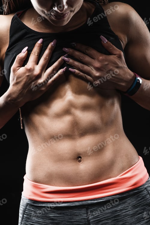 Preview: Sporty girl with great abdominal muscles in black sportswear.