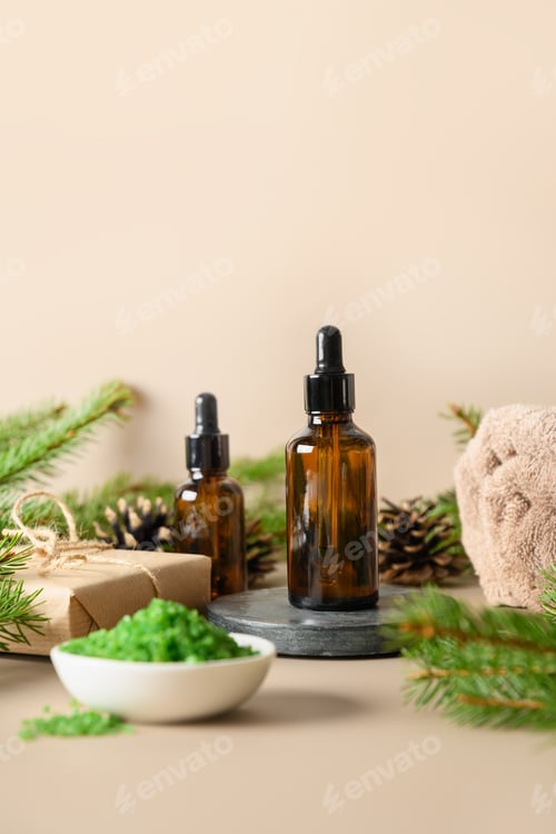 Preview: Christmas Spa wellness concept with cosmetic oil, pine cones on beige background.