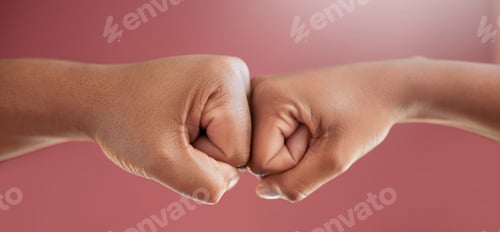 Preview: Cropped shot of two unrecognizable people fist bumping in studio against a red background
