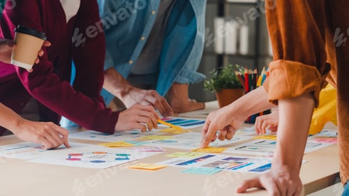 Preview: Asian businessmen and businesswomen meeting brainstorming ideas working together in small office.