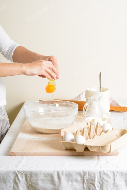 Preview: Crop woman pouring egg in bowl