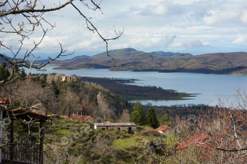 Preview: a house on top of a hill near a lake with trees