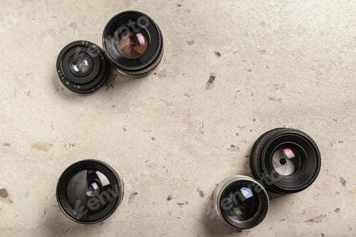 Preview: Different camera lenses arranged on a textured surface ready for photography