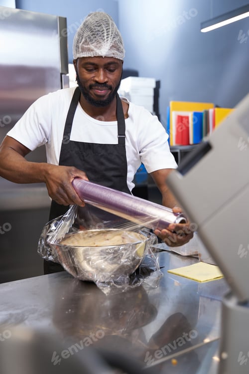 Preview: Male in black apron preparing ingredients in the kitchen