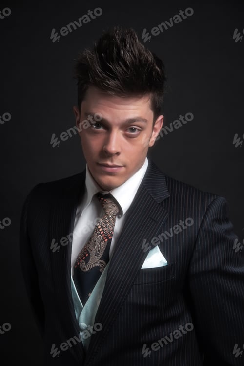 Preview: Casual Stylish Young Business Man Wearing Dark Blue Striped Jacket With Tie And Gilet. Studio Shot
