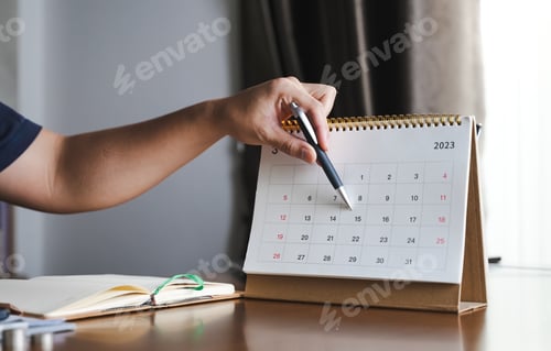 Preview: people hand holding the pen pointing on calenda, concept of schedule check and plan check.