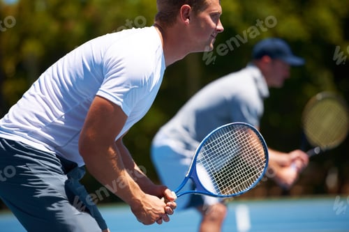Preview: Team tennis. Shot of two men playing a tennis match on a sunny day.