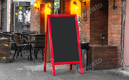 Preview: Blank black sandwich board on a street