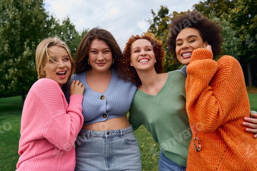 Preview: Stylish friends enjoying a vibrant spring day in a lush green park