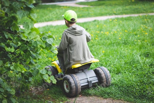 Preview: Child Rides Toy ATV on Green Grassy Lawn