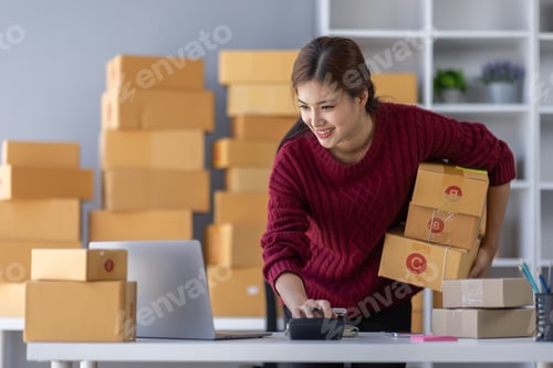 Preview: Startup small business entrepreneur or freelance Asian woman using a laptop with box, Young success