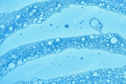 Preview: The texture of soap bubbles and foam in close-up on a blue background.