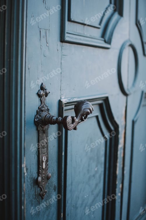 Preview: Vertical closeup shot of a vintage metal handle of a blue old door