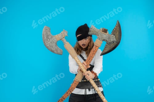 Preview: Confident young pirate holding axes and looking at camera