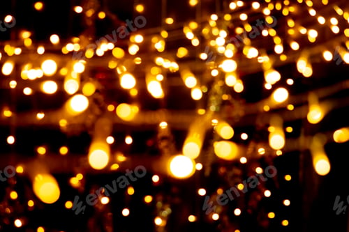 Preview: Blurry garland lights on a dark background. Festive Christmas and New Year background. Soft focus
