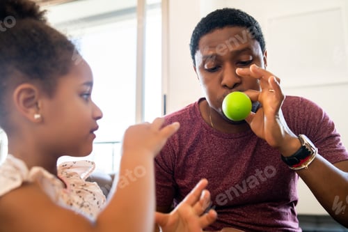 Preview: Daughter and father playing together at home.