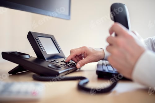 Preview: Business Professional Dials Landline Telephone at Workplace