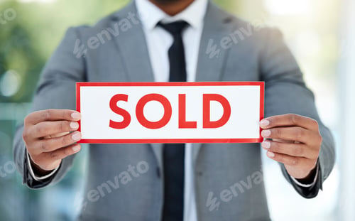 Preview: Cropped shot of an unrecognizable businessman holding up a sold sign while standing in the office