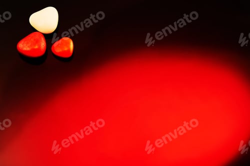 Preview: Valentine's Day candies on red black background. Red candy hearts with space for text