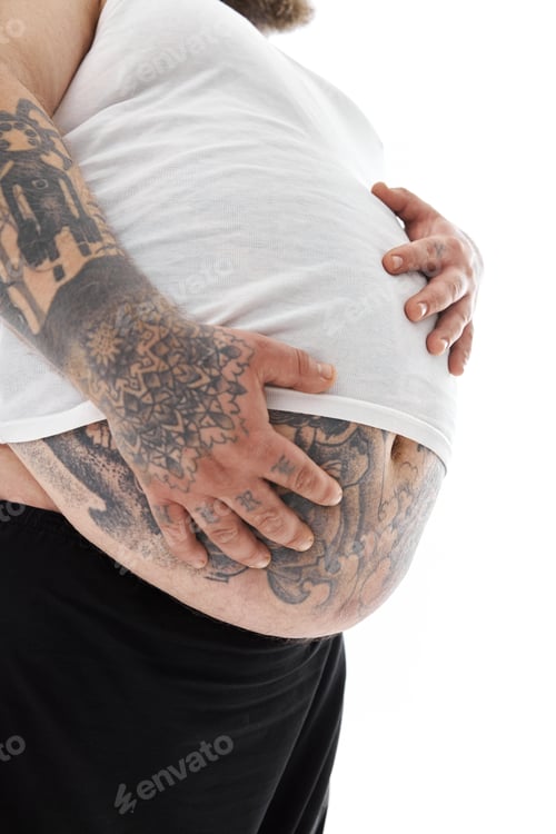 Preview: Happy fat man with big belly and tattoes in sports wear is holding his stomach