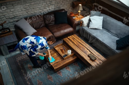Preview: Asian woman dusting in living room