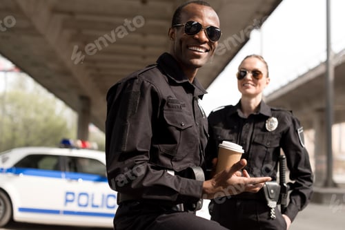 Preview: happy young police officers having coffee break