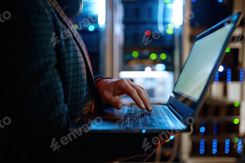 Preview: IT technician checking the servers vitals using laptop computer