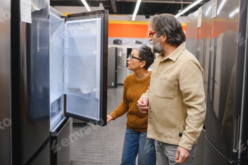 Preview: Mature couple choosing new refrigerator in electronics store