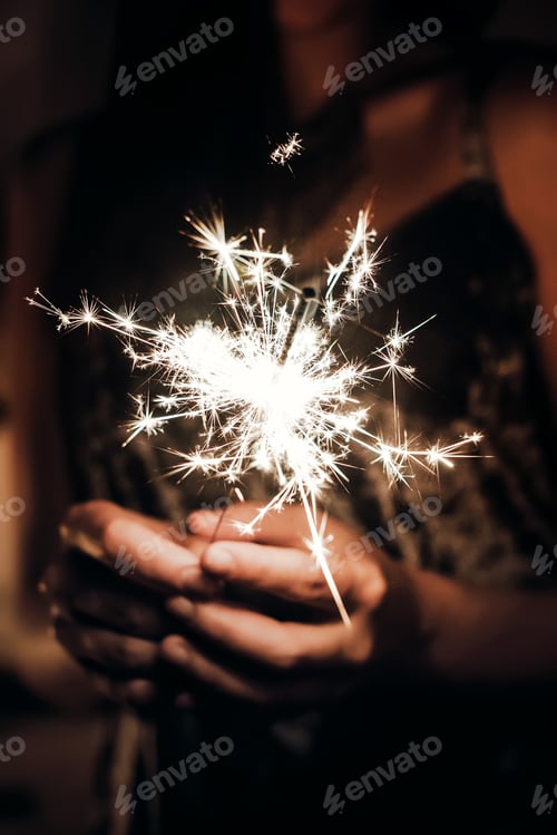 Preview: Beautiful stylish woman holding burning sparkler bengal light