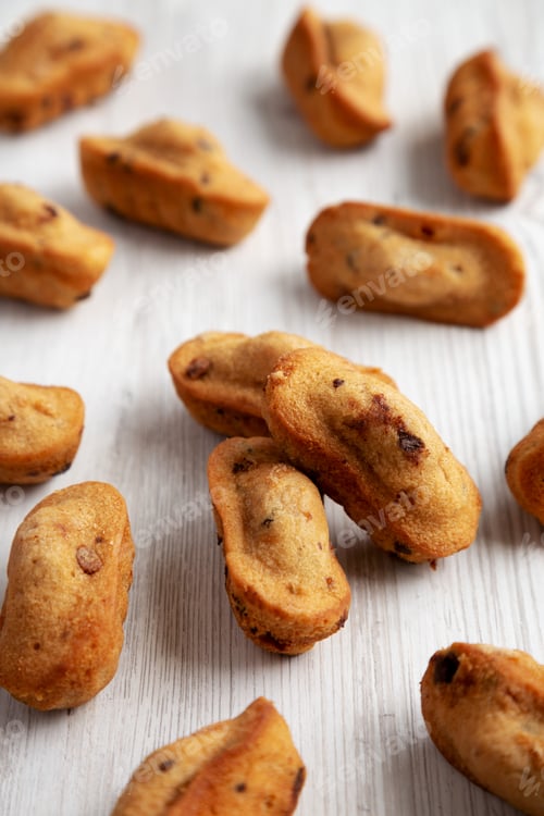 Preview: Homemade Chocolate Chips Madeleines on a white wooden background, side view.
