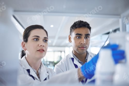 Preview: Two diverse scientists working in a lab together. Mixed race man and caucasian woman finding a cur