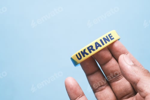 Preview: Hand with blue and yellow wristband , colors of flag of Ukraine.