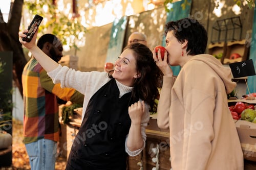 Preview: Cheerful customer and business owner taking photos on mobile phone