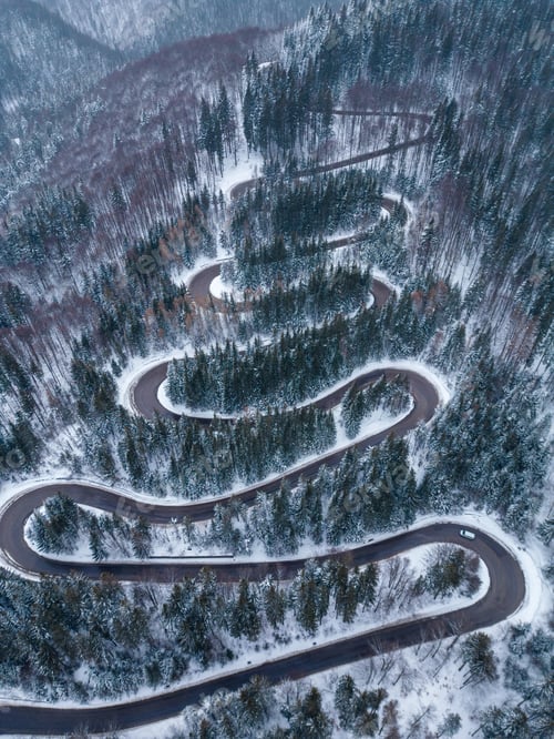 Preview: Aerial top down view of winter winding road in the forest, Transylvania, Romania.